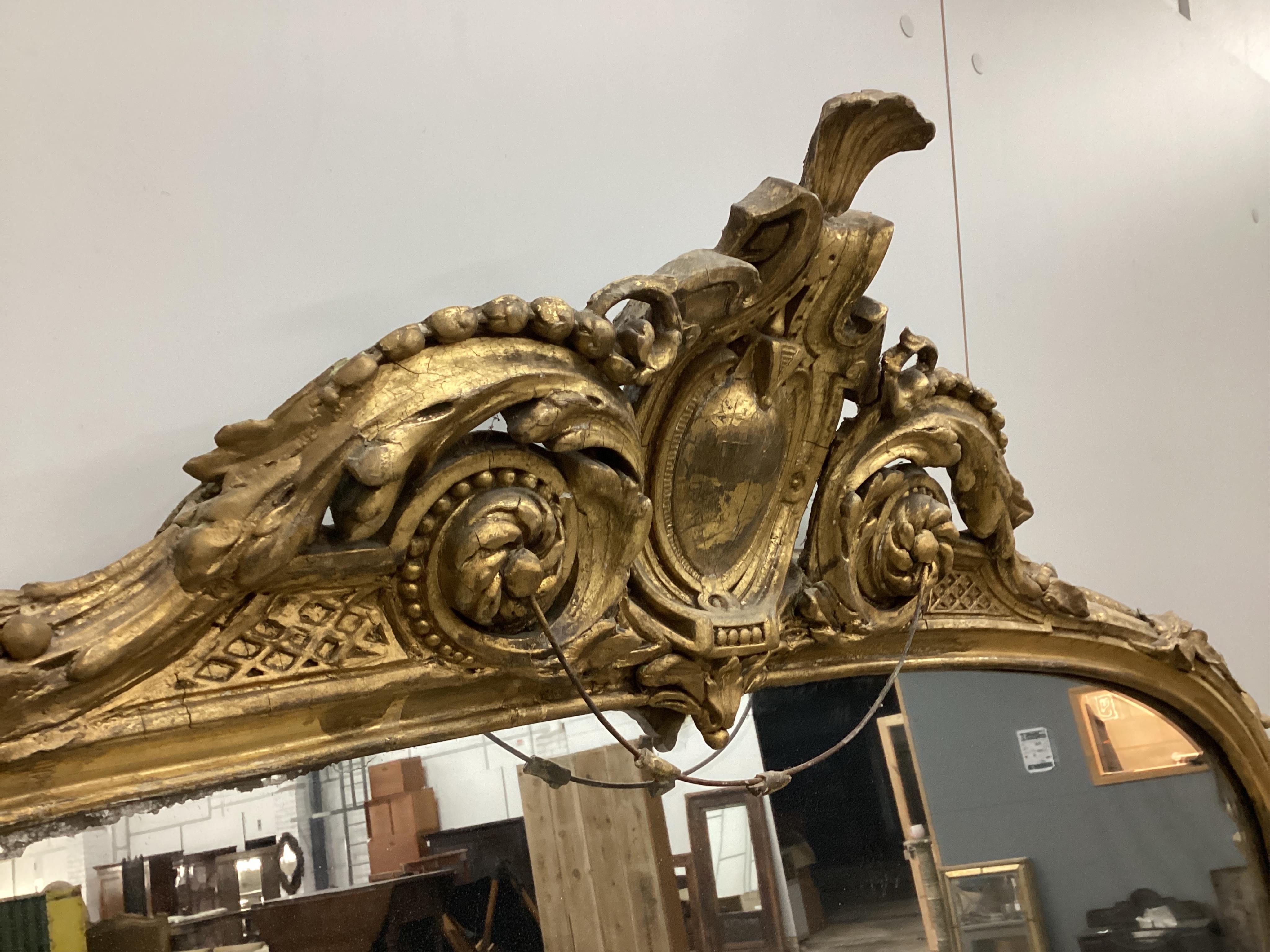 A Victorian giltwood and composition overmantel mirror with cartouche pediment, width 140cm, height 201cm. Condition - fair, three areas of lost gesso